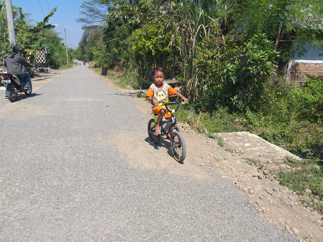 Nikmati Jalan Baru Hasil TMMD , Rafa Asyik Main Sepeda