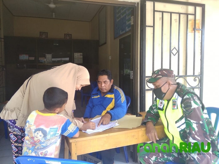 Babinsa dan Babinkamtibmas Memantau Pembagian Sembako di Desa Binaan