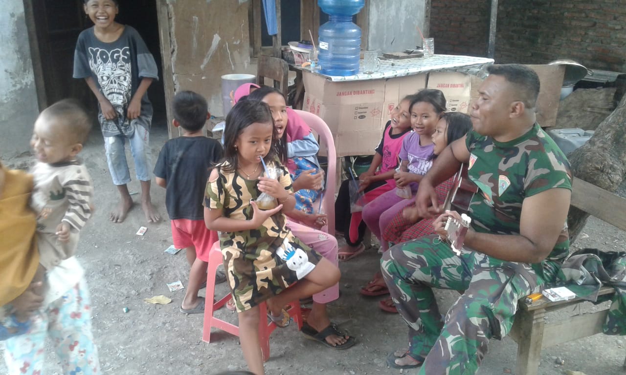 . Ditengah Keceriaan TMMD, Serda Matiyus Hibur Anak Dengan Lagu Kebangsaan