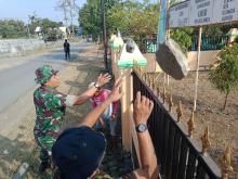  TNI Singkirkan Batu Di Depan Balai Desa